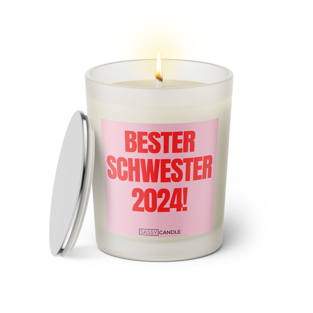 Duftkerze mit witzigem Spruch: Bester Schwester 2024. Farbe rosa und pinke Schrift. Kerzenglas mit silbernem Deckel von SassyCandle.