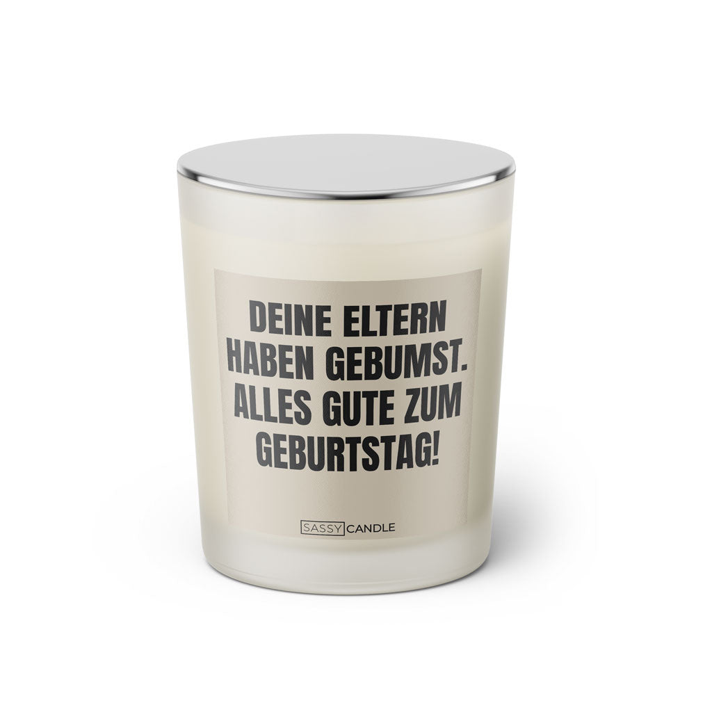 Duftkerze mit witzigem Spruch: Deine Eltern haben gebumst. Alles Gute zum Geburtstag. Farbe beige und schwarze Schrift. Kerzenglas mit silbernem geschlossenem Deckel von SassyCandle.
