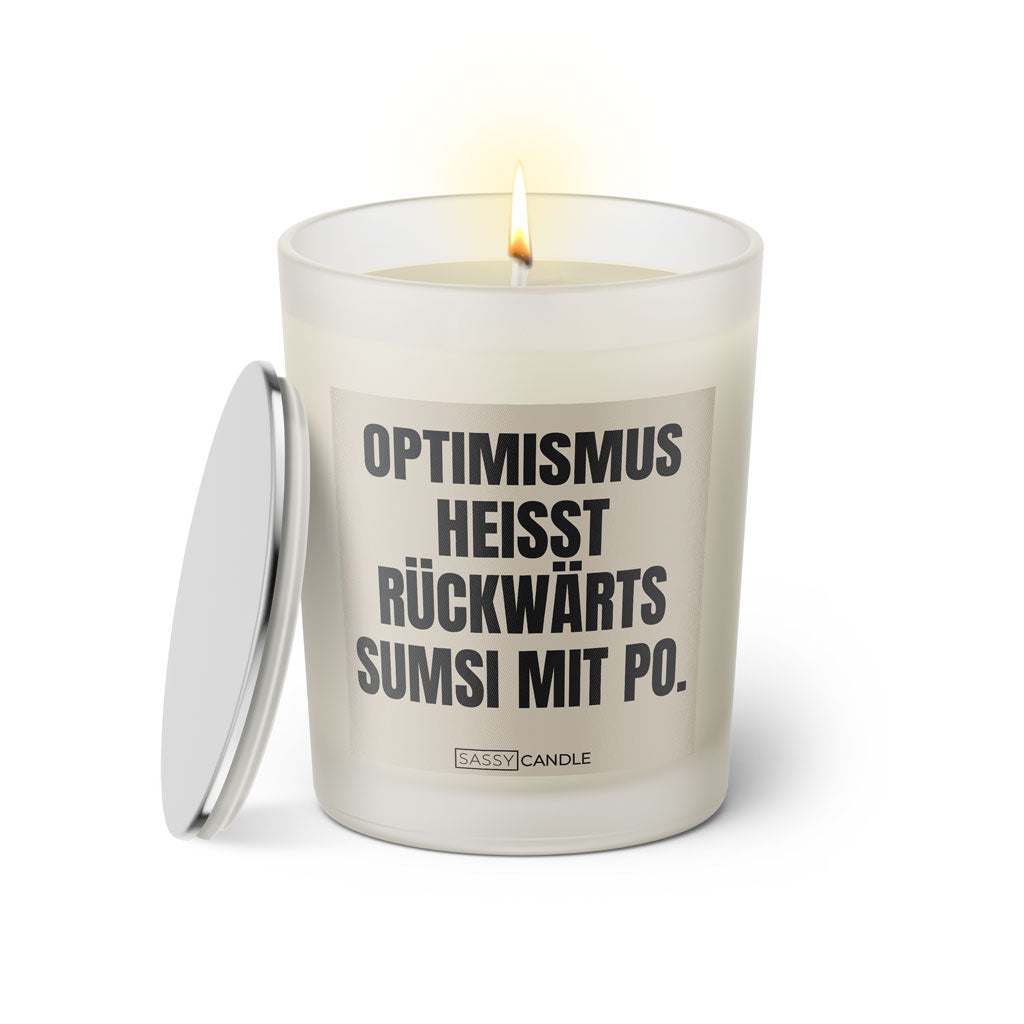 Duftkerze mit witzigem Spruch: Optimismus heißt rückwärts Sumsi mit Po. Farbe beige und schwarze Schrift. Kerzenglas mit silbernem Deckel von SassyCandle.