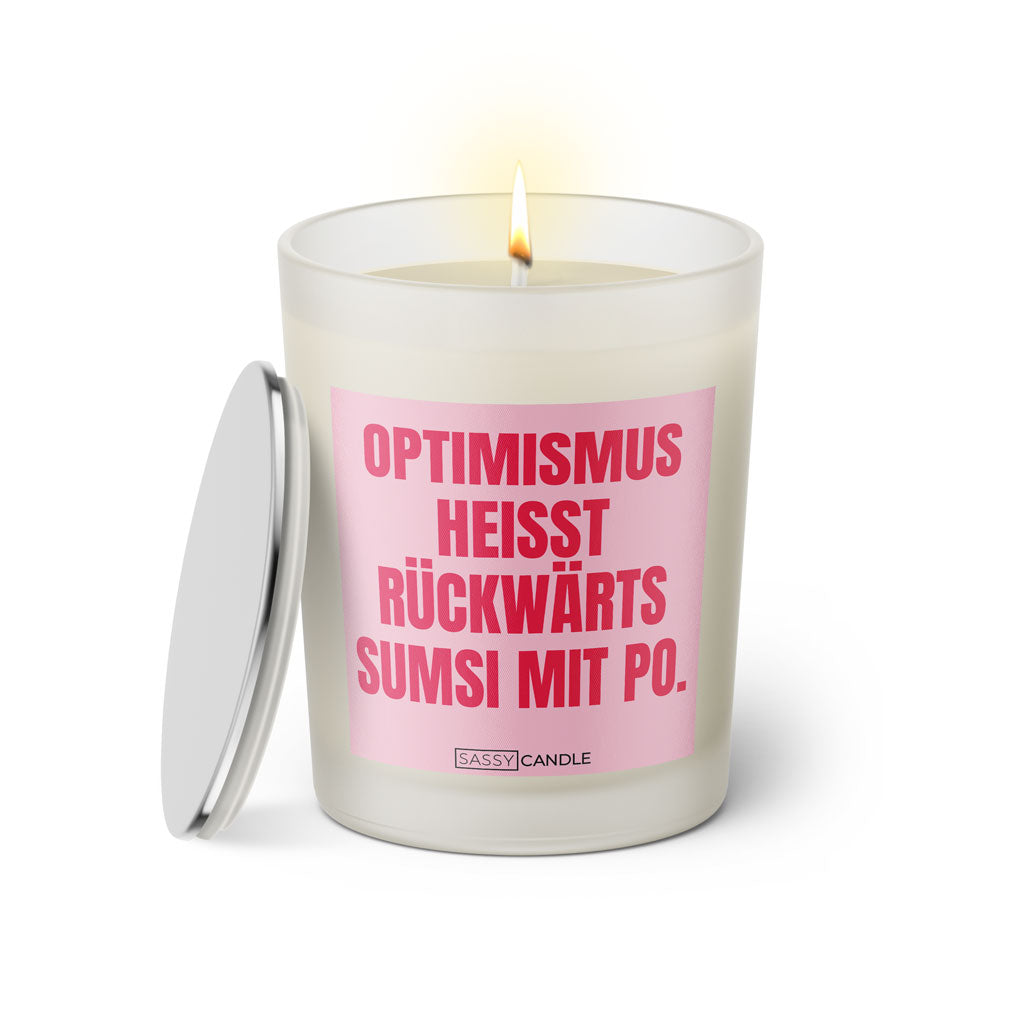 Duftkerze mit witzigem Spruch: Optimismus heißt rückwärts Sumsi mit Po. Farbe rosa und pinke Schrift. Kerzenglas mit silbernem Deckel von SassyCandle.