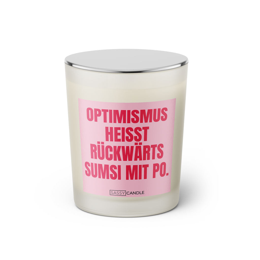 Duftkerze mit witzigem Spruch: Optimismus heißt rückwärts Sumsi mit Po. Farbe rosa und pinke Schrift. Kerzenglas mit silbernem Deckel von SassyCandle.