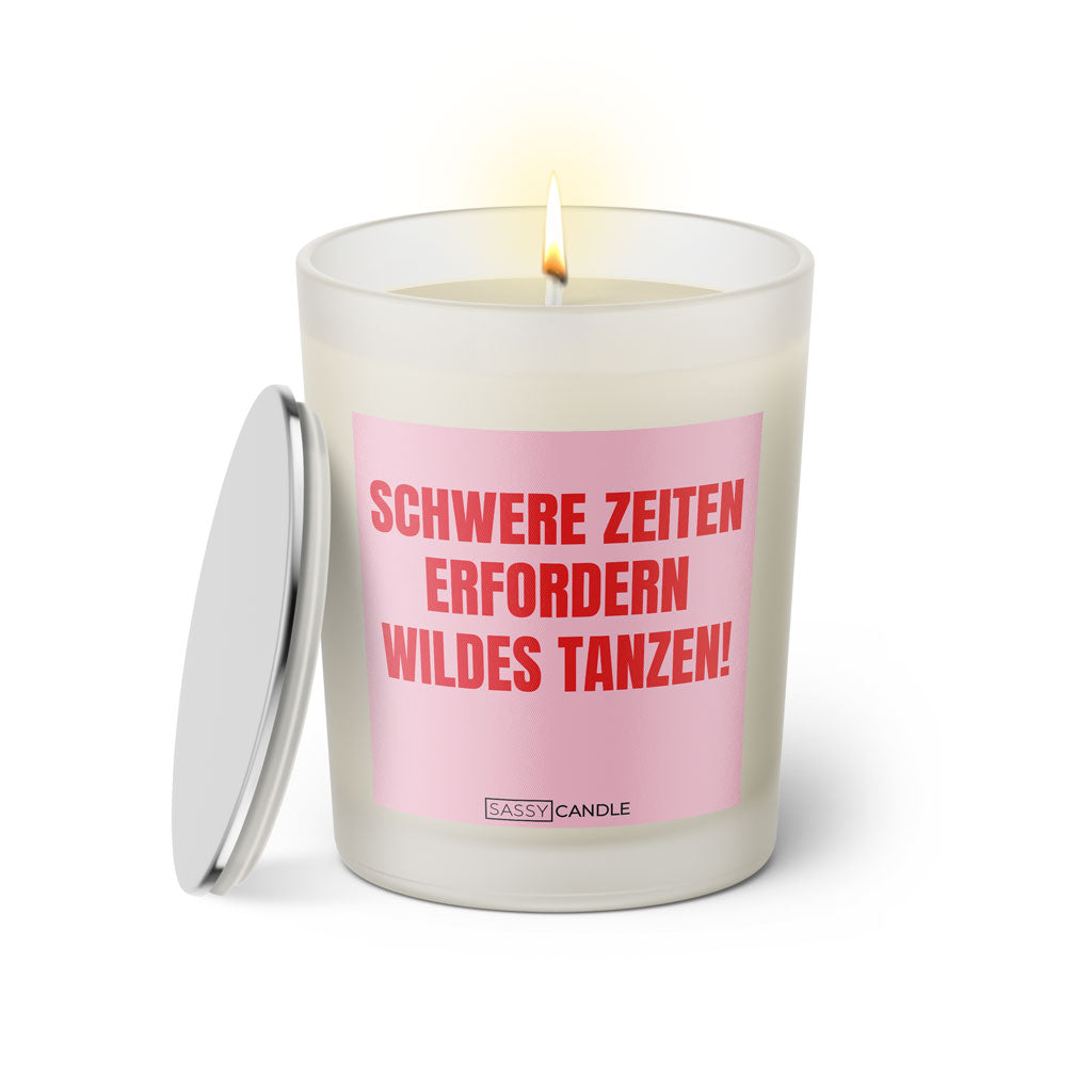 Duftkerze mit witzigem Spruch: Schwere Zeiten erfordern wildes tanzen. Farbe rosa und pinke Schrift. Kerzenglas mit silbernem Deckel von SassyCandle.