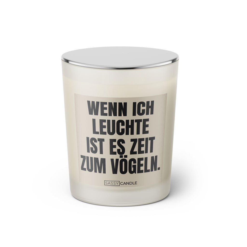 Duftkerze mit witzigem Spruch: Wenn ich leuchte ist es Zeit zum vögeln. Farbe beige und schwarze Schrift. Kerzenglas mit silbernem geschlossenem Deckel von SassyCandle.