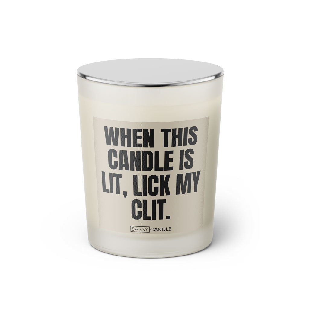 Duftkerze mit witzigem Spruch: When this candle is lit, lick my clit. Farbe beige und schwarze Schrift. Kerzenglas mit silbernem Deckel von SassyCandle.