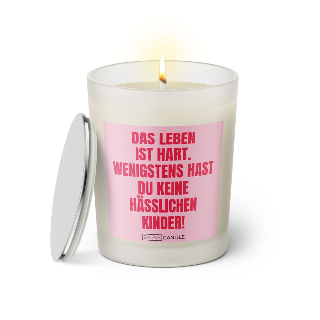 Duftkerze mit witzigem Spruch: Das Leben ist hart. Wenigstens hast du keine hässlichen Kinder. Farbe rosa und pinke Schrift. Kerzenglas mit silbernem geschlossenem Deckel von SassyCandle.