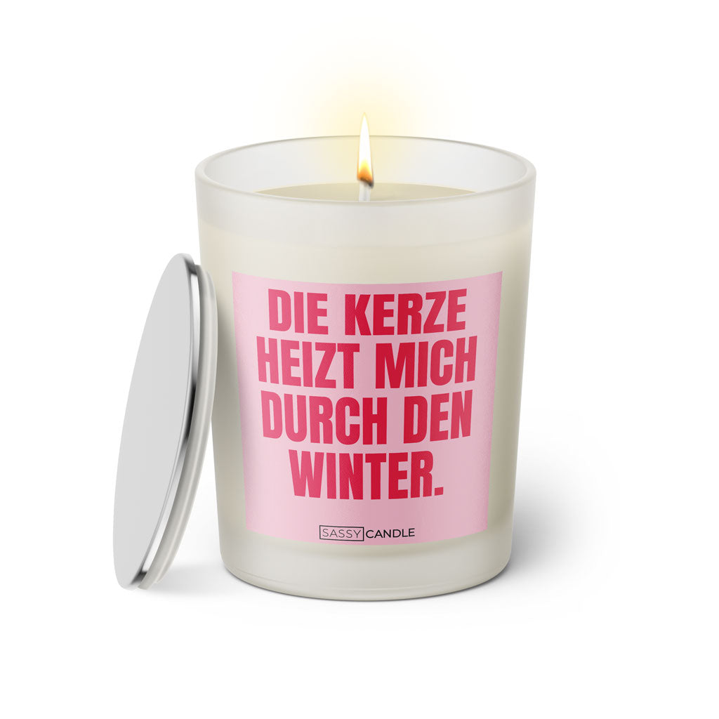 Duftkerze mit witzigem Spruch: Die Kerze heizt mich durch den Winter. Farbe rosa und pinke Schrift. Kerzenglas mit silbernem Deckel von SassyCandle.