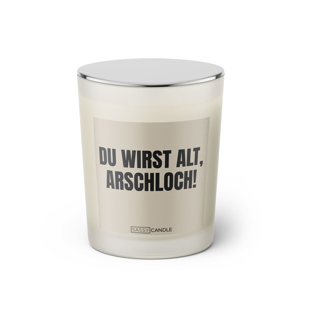 Duftkerze mit witzigem Spruch: Du wirst alt Arschloch. Farbe beige und schwarze Schrift. Kerzenglas mit silbernem geschlossenem Deckel von SassyCandle.