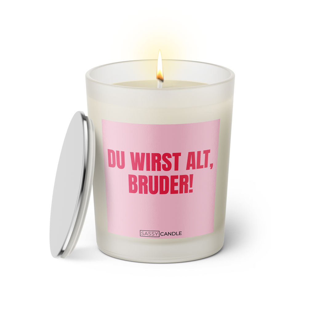 Duftkerze mit witzigem Spruch: Du wirst alt Bruder. Farbe rosa und pinke Schrift. Kerzenglas mit silbernem Deckel von SassyCandle.