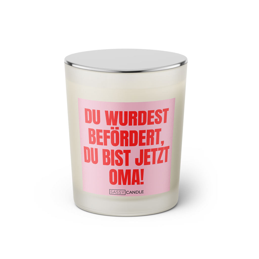 Duftkerze mit witzigen Spruch: Du wurdest befördert, du bist jetzt Oma! Kerzenglas mit silbernen Deckel von Sassy Candle. Farbe rosa und pink.