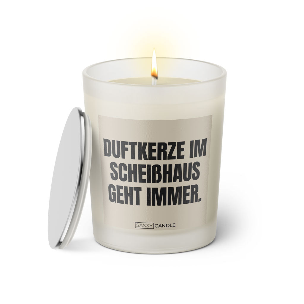 Duftkerze mit witzigem Spruch: Duftkerze im Scheisshaus geht immer. Farbe beige und schwarze Schrift. Kerzenglas mit silbernem Deckel von SassyCandle.