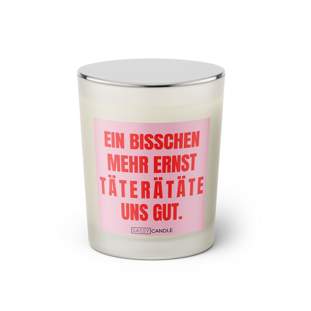 Duftkerze mit witzigen Spruch: Ein bisschen mehr Ernst taterätäte uns gut. Kerzenglas mit silbernen Deckel von Sassy Candle. Farbe rosa und pink.