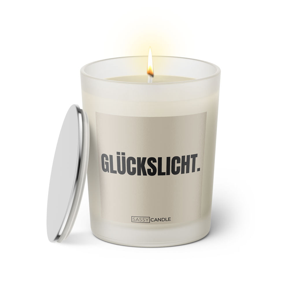 Duftkerze mit witzigen Spruch: Glückslicht. Kerzenglas mit silbernen Deckel. Farbe beige und schwarz von Sassy Candle.