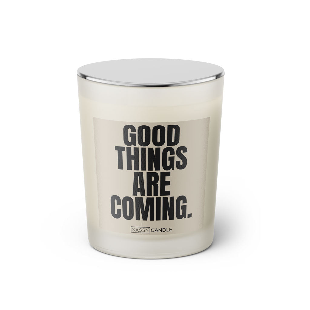 Duftkerze mit witzigem Spruch: Good things are coming. Farbe beige und schwarze Schrift. Kerzenglas mit silbernem geschlossenem Deckel von SassyCandle.