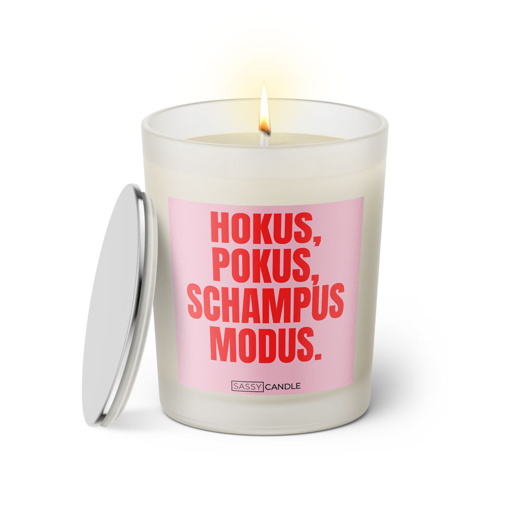 Duftkerze mit witzigem Spruch: Hokus Pokus Schampus Modus. Farbe rosa und pinke Schrift. Kerzenglas mit silbernem Deckel von SassyCandle.