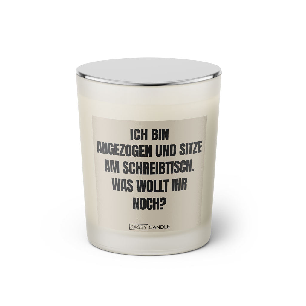 Duftkerze mit witzigem Spruch:Ich bin angezogen und sitze am Schreibtisch. Was wollt ihr noch? Farbe beige und schwarz mit silbernem Deckel von Sassy Candle.