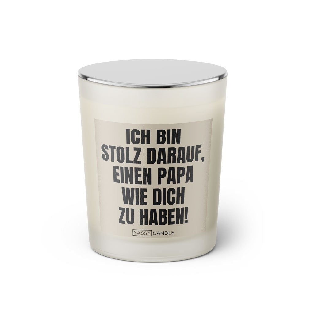 Duftkerze mit witzigem Spruch: Ich bin stolz darauf, einen Papa wie dich zu haben! Farbe beige und schwarz mit silbernem Deckel von Sassy Candle.