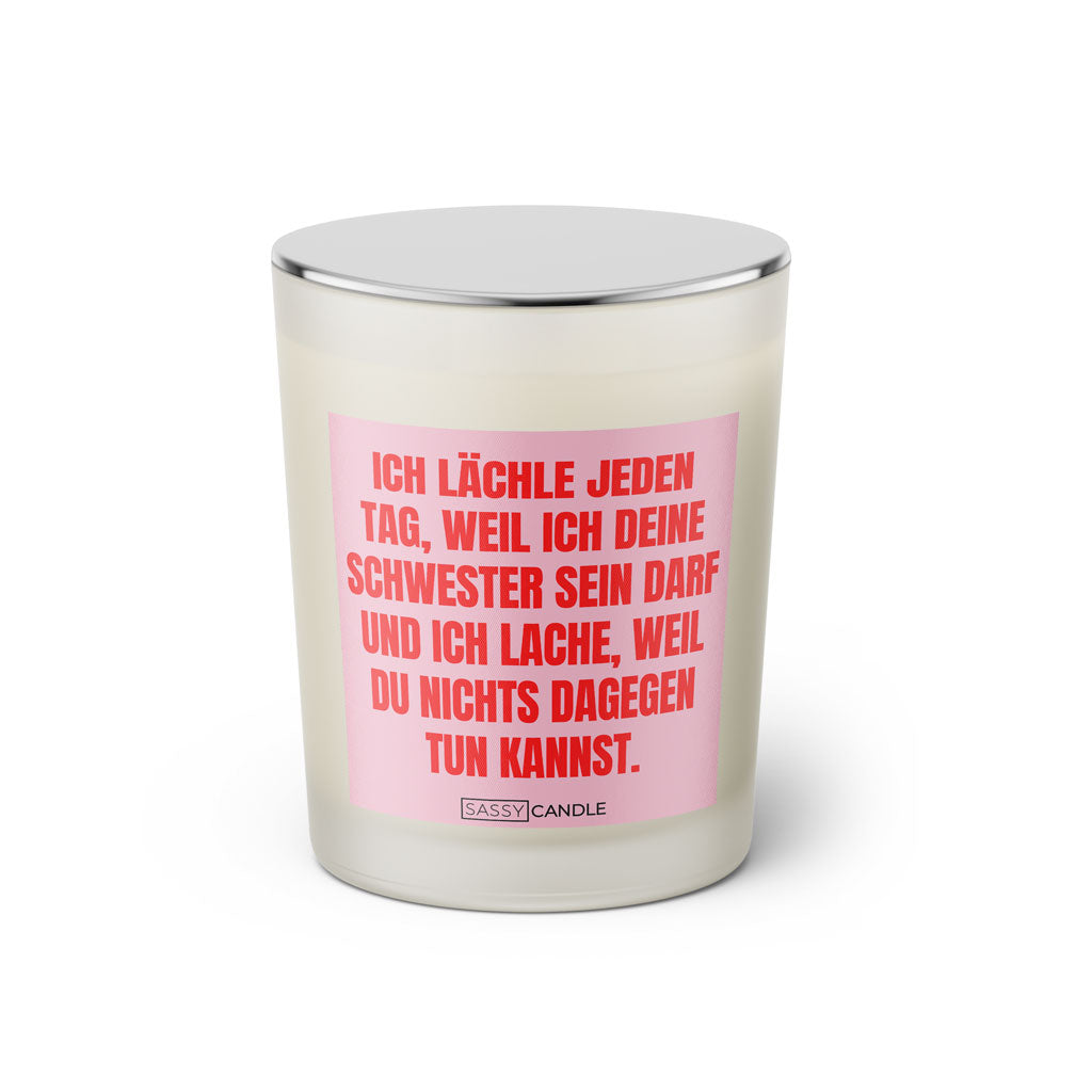 Duftkerze mit witzigen Spruch: Ich lächle jeden Tag, weil ich deine Schwester sein darf und ich lache, weil du nichts dagegen tun kannst. Kerzenglas mit silbernen Deckel. Farbe rosa und pink von Sassy Candle.