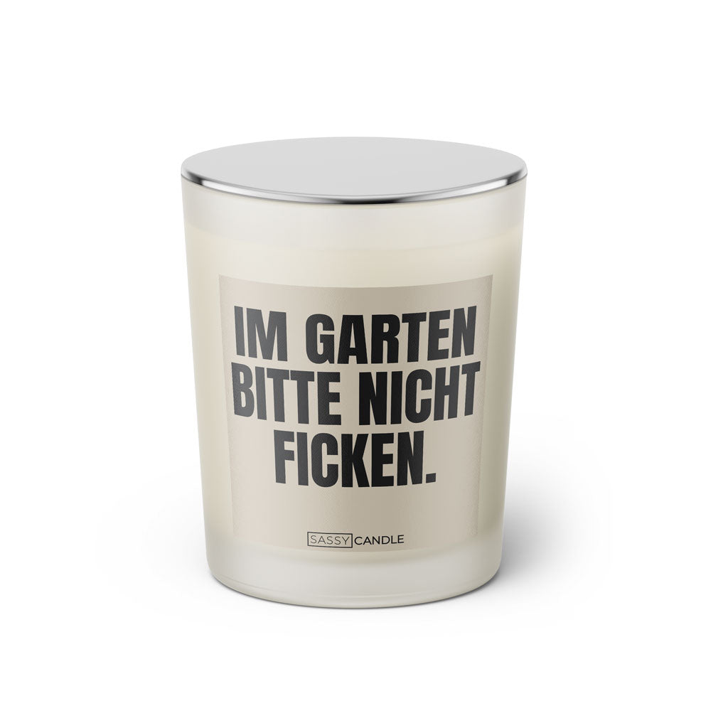 Duftkerze mit witzigem Spruch: Im Garten bitte nicht ficken. Farbe beige und schwarze Schrift. Kerzenglas mit silbernem geschlossenem Deckel von SassyCandle.