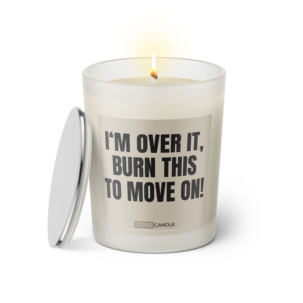 Duftkerze mit witzigem Spruch: I'm over it, burn this to move on! Farbe beige und schwarze Schrift. Kerzenglas mit silbernem Deckel von SassyCandle.