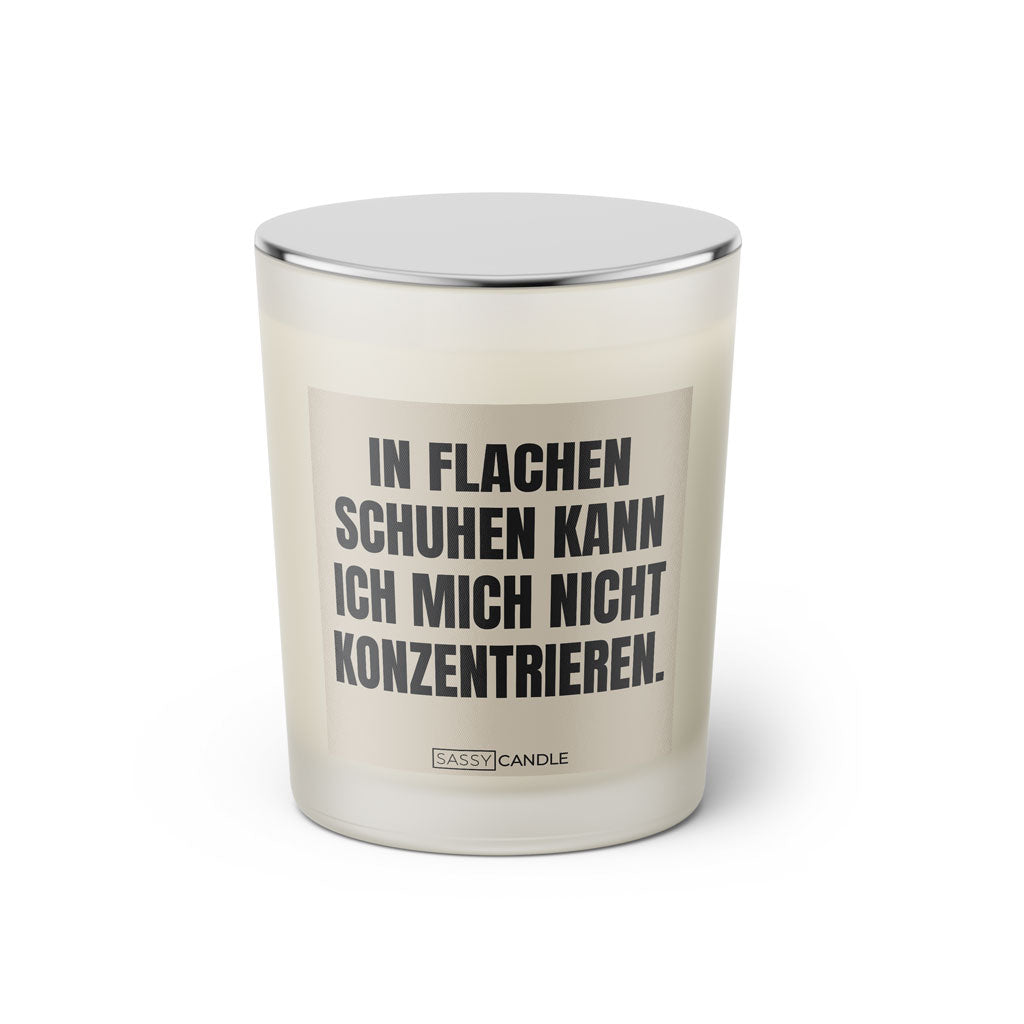Duftkerze mit witzigem Spruch: In flachen Schuhen kann ich mich nicht konzentrieren. Farbe beige und schwarze Schrift. Kerzenglas mit silbernem geschlossenem Deckel von SassyCandle.
