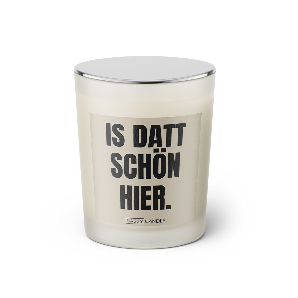 Duftkerze mit witzigem Spruch: Is datt schön hier. Farbe beige und schwarze Schrift. Kerzenglas mit silbernem geschlossenem Deckel von SassyCandle.