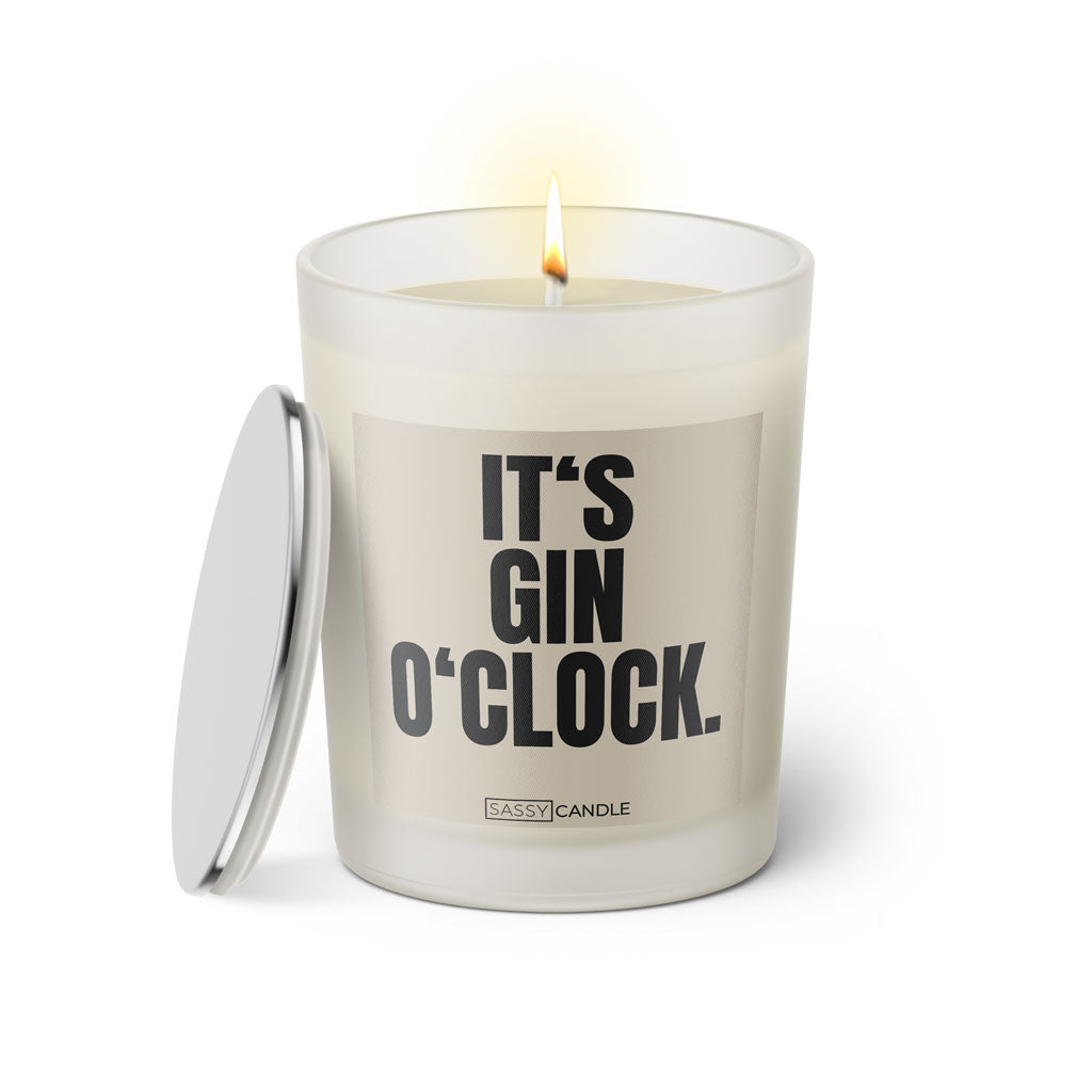 Duftkerze mit witzigem Spruch: It’s Gin O’Clock. Farbe beige und schwarze Schrift. Kerzenglas mit silbernem Deckel von SassyCandle.