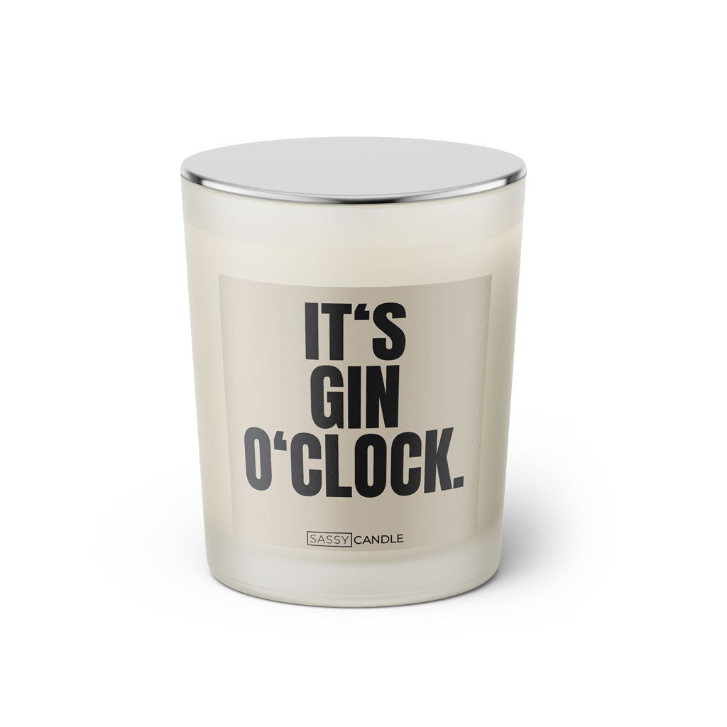 Duftkerze mit witzigem Spruch: It’s Gin O’Clock. Farbe beige und schwarze Schrift. Kerzenglas mit silbernem geschlossenem Deckel von SassyCandle.