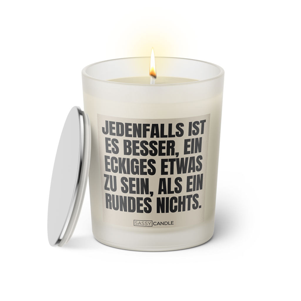Duftkerze mit witzigen Spruch: Jedenfalls ist es besser, ein eckiges Etwas zu sein, als ein rundes Nichts. Farbe beige und schwarz von Sassy Candle.