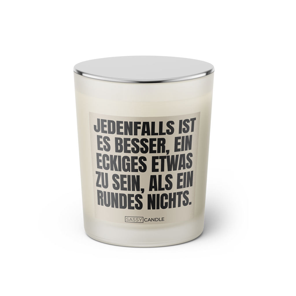 Duftkerze mit witzigen Spruch: Jedenfalls ist es besser, ein eckiges Etwas zu sein, als ein rundes Nichts. Farbe beige und schwarz von Sassy Candle.
