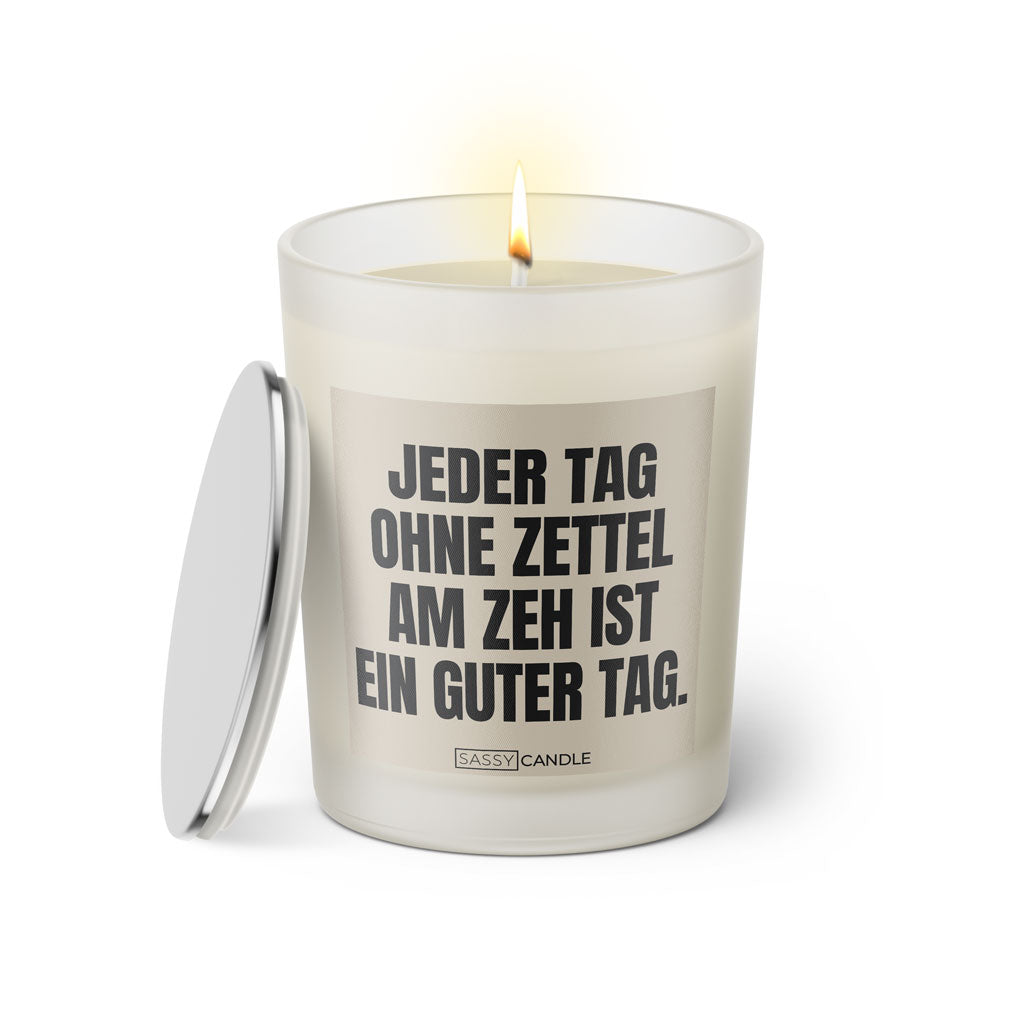Duftkerze mit witzigen Spruch: Jeder Tag ohne Zettel am Zeh ist ein guter Tag. Kerzenglas mit silbernen Deckel von Sassy Candle. Farbe beige und schwarz.