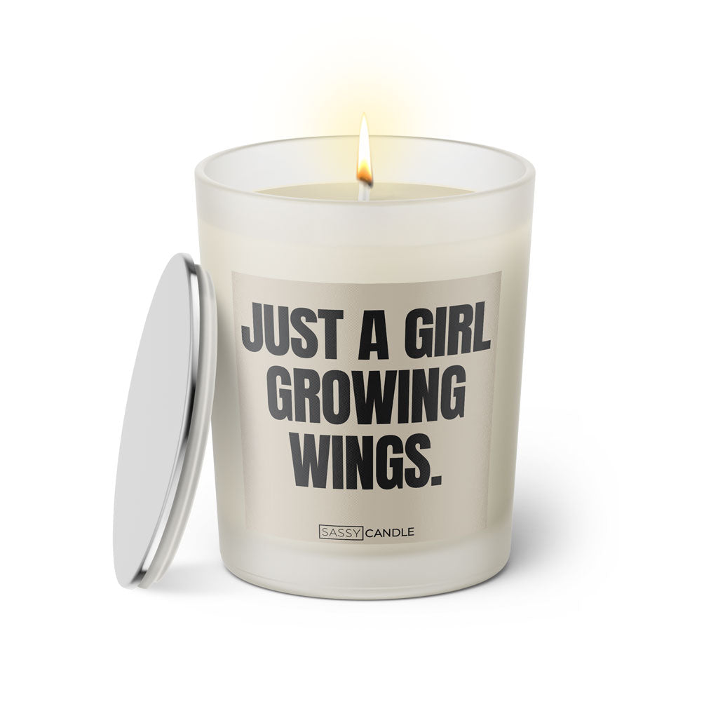 Duftkerze mit witzigen Spruch: Just a Girl growing wings. Farbe beige und schwarz von Sassy Candle.