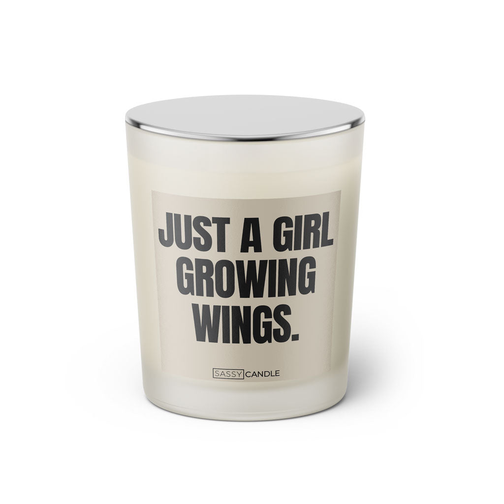 Duftkerze mit witzigen Spruch: Just a Girl growing wings. Farbe beige und schwarz von Sassy Candle.