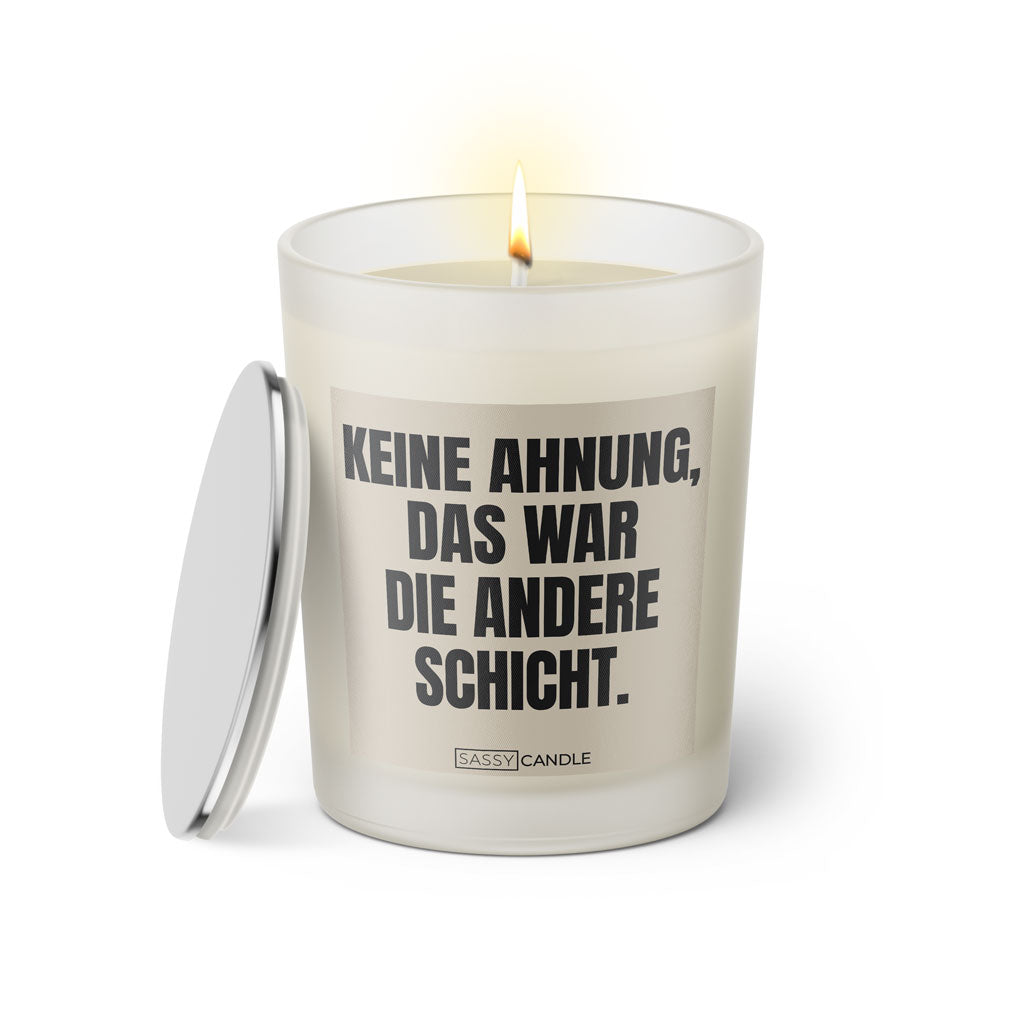 Duftkerze mit witzigem Spruch: Keine Ahnung, das war die andere Schicht. Farbe beige und schwarz mit silbernem Deckel von Sassy Candle.