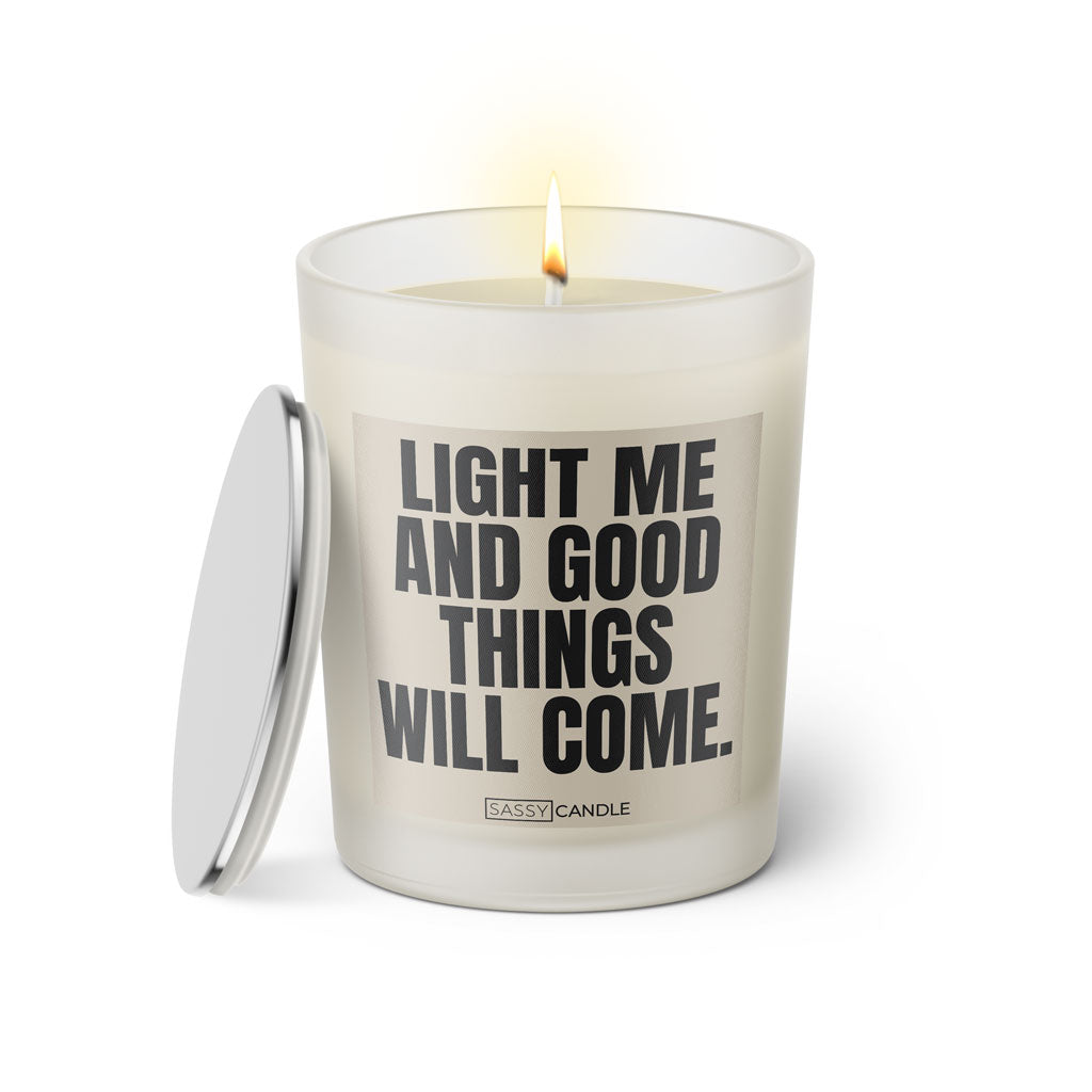 Duftkerze mit witzigem Spruch: Light me and good things will come. Farbe beige und schwarze Schrift. Kerzenglas mit silbernem Deckel von SassyCandle.