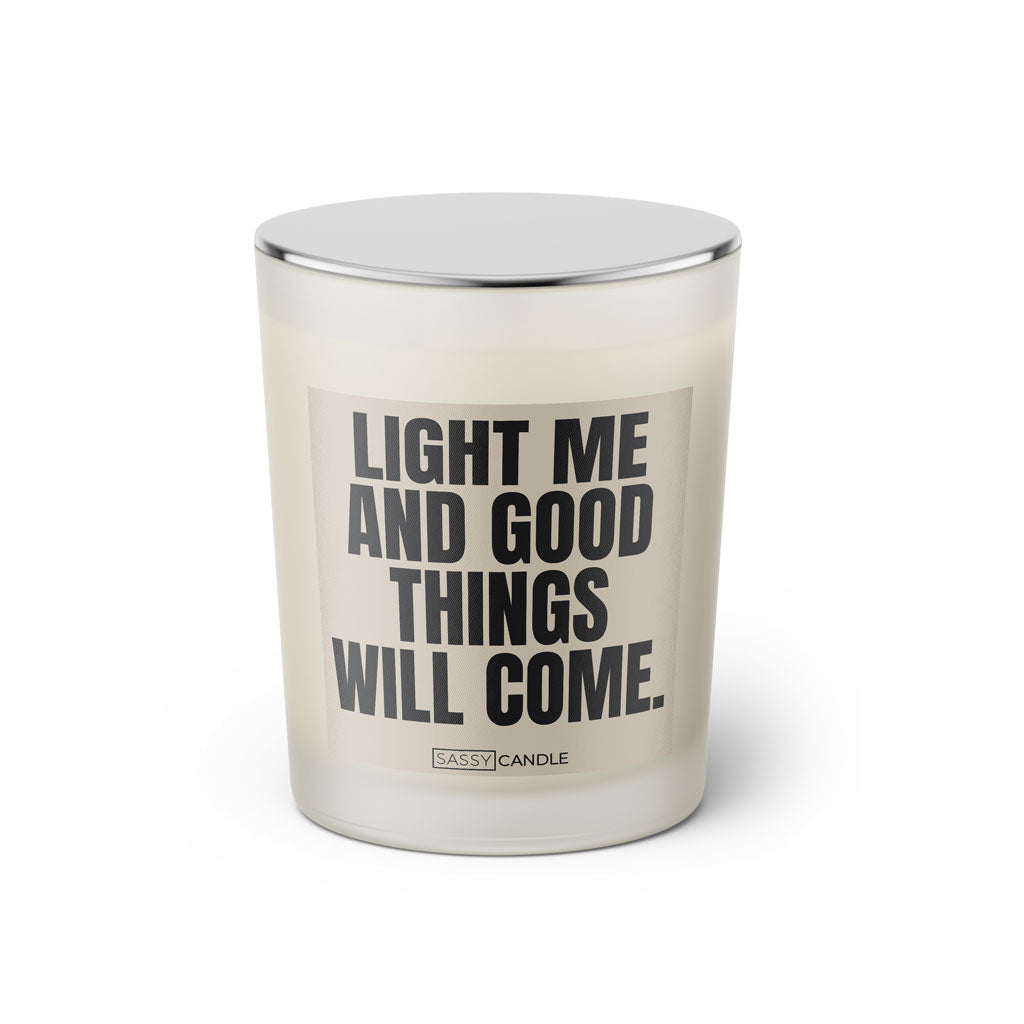 Duftkerze mit witzigem Spruch: Light me and good things will come. Farbe beige und schwarze Schrift. Kerzenglas mit silbernem geschlossenem Deckel von SassyCandle.