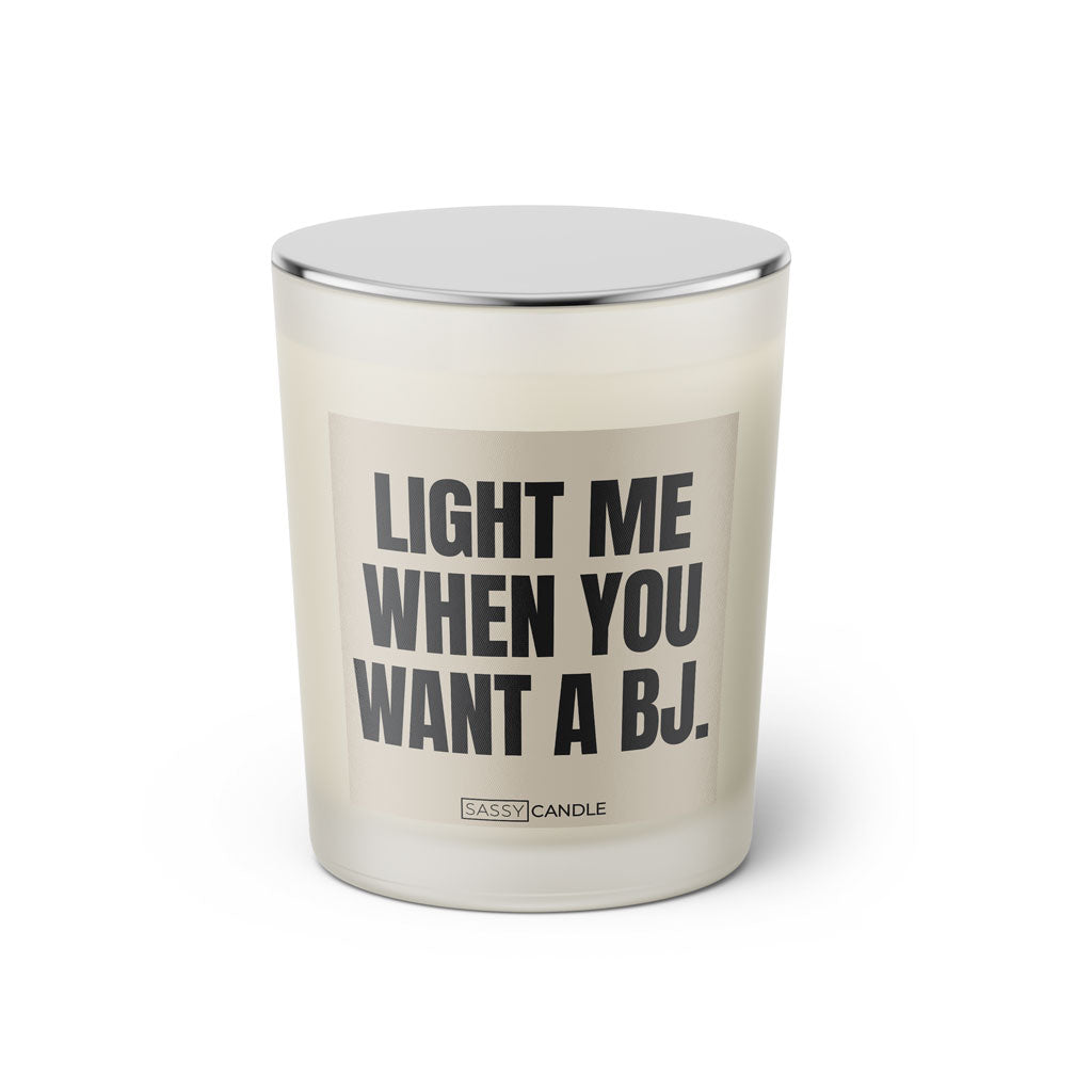 Duftkerze mit witzigem Spruch: Light me when you want a BJ. Farbe beige und schwarze Schrift. Kerzenglas mit silbernem Deckel von SassyCandle.