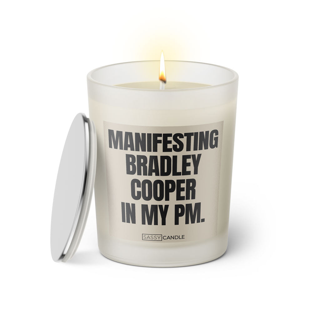 Duftkerze mit witzigen Spruch: Manifesting Bradley Cooper in my PM. Farbe beige und schwarz von Sassy Candle.