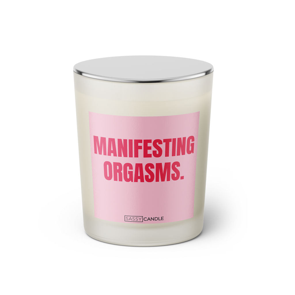 Duftkerze mit witzigem Spruch: Manifesting Orgasms. Farbe rosa und pinke Schrift. Kerzenglas mit silbernem geschlossenem Deckel von SassyCandle.