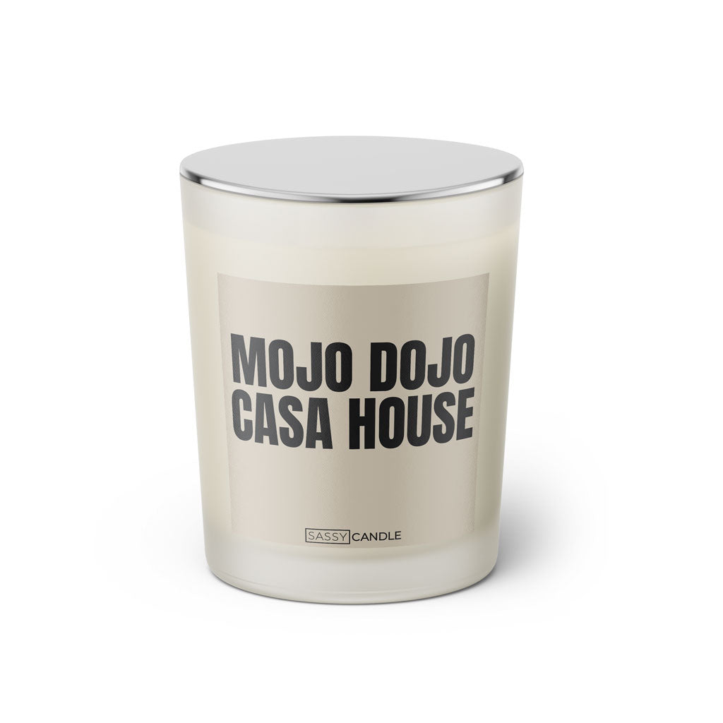 Duftkerze mit witzigem Spruch: Mojo Dojo Casa House. Farbe beige und schwarze Schrift. Kerzenglas mit silbernem geschlossenem Deckel von SassyCandle.