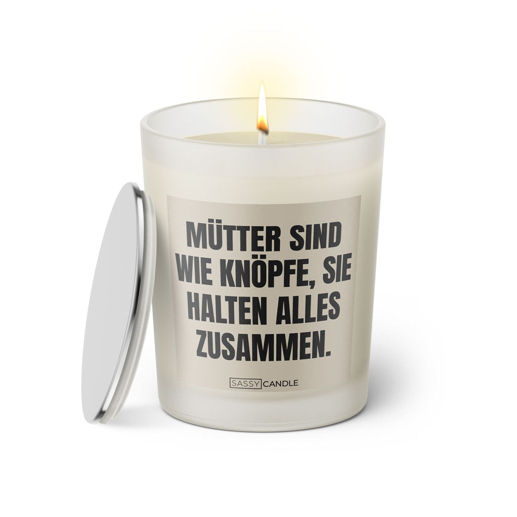 Duftkerze mit witzigem Spruch: Mütter sind wie Knöpfe, sie halten alles zusammen. Farbe beige und schwarz mit silbernem Deckel von Sassy Candle.