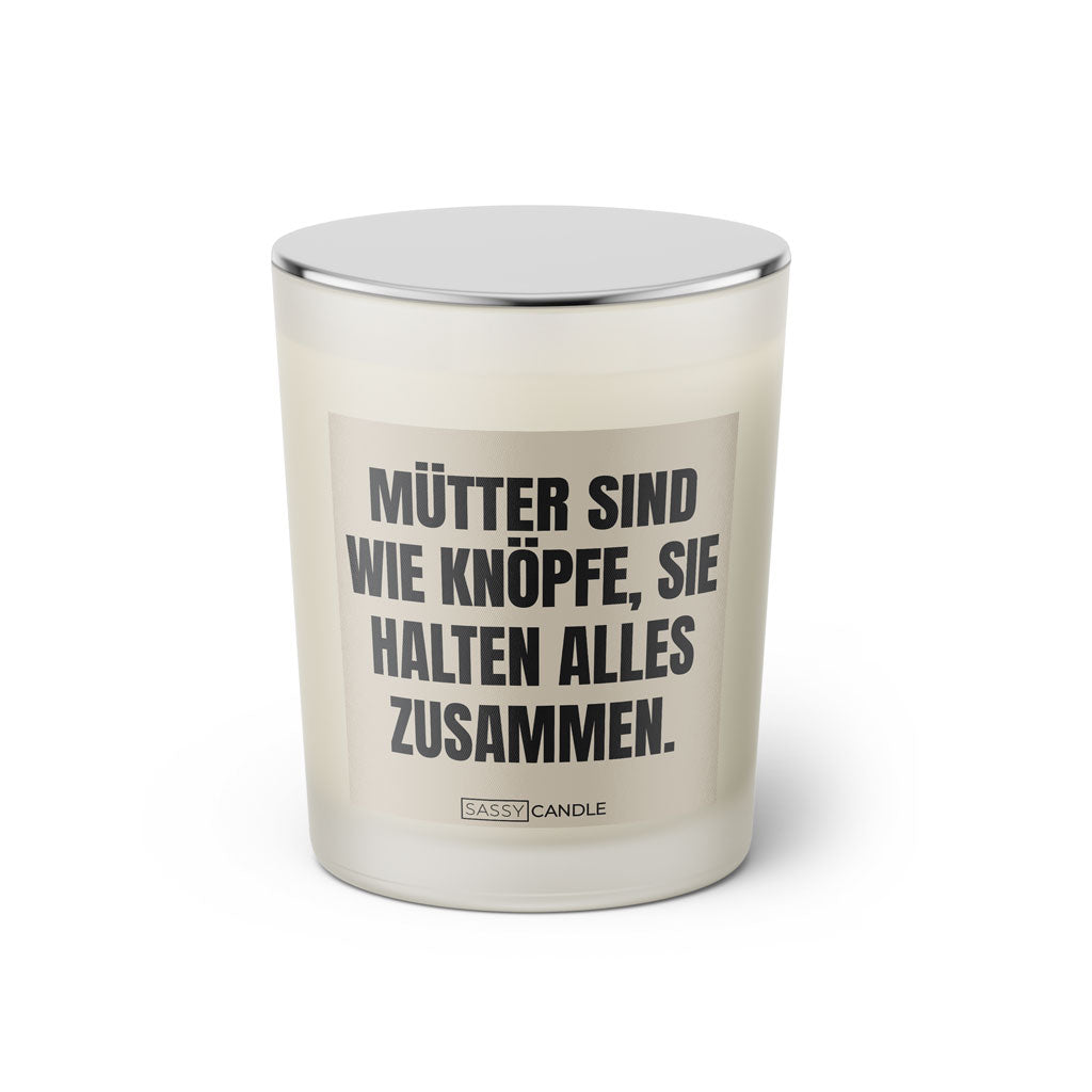 Duftkerze mit witzigem Spruch: Mütter sind wie Knöpfe, sie halten alles zusammen. Farbe beige und schwarz mit silbernem Deckel von Sassy Candle.