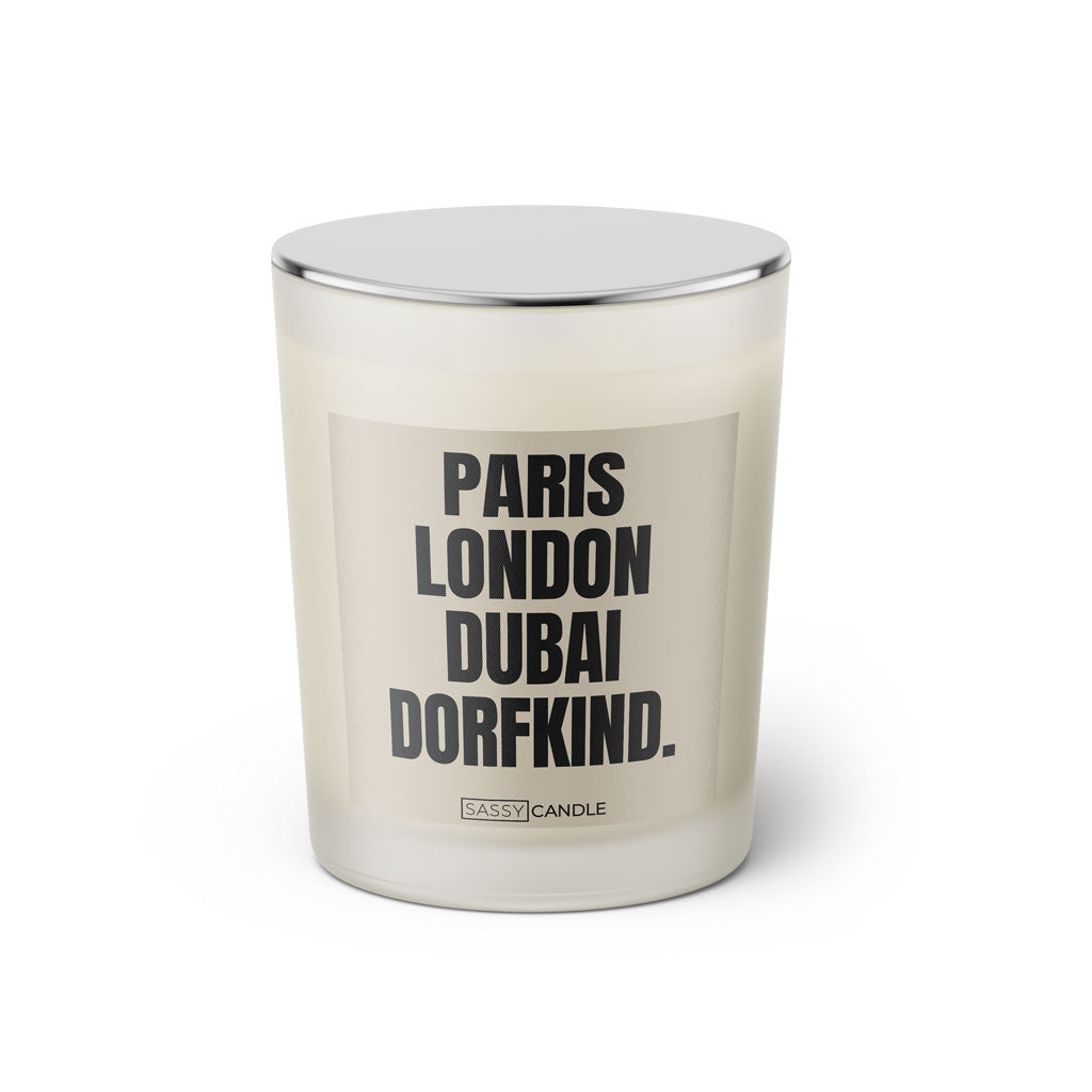 Duftkerze mit Spruch: Paris London Dubai Dorfkind. Farbe beige und schwarz von Sassy Candle.
