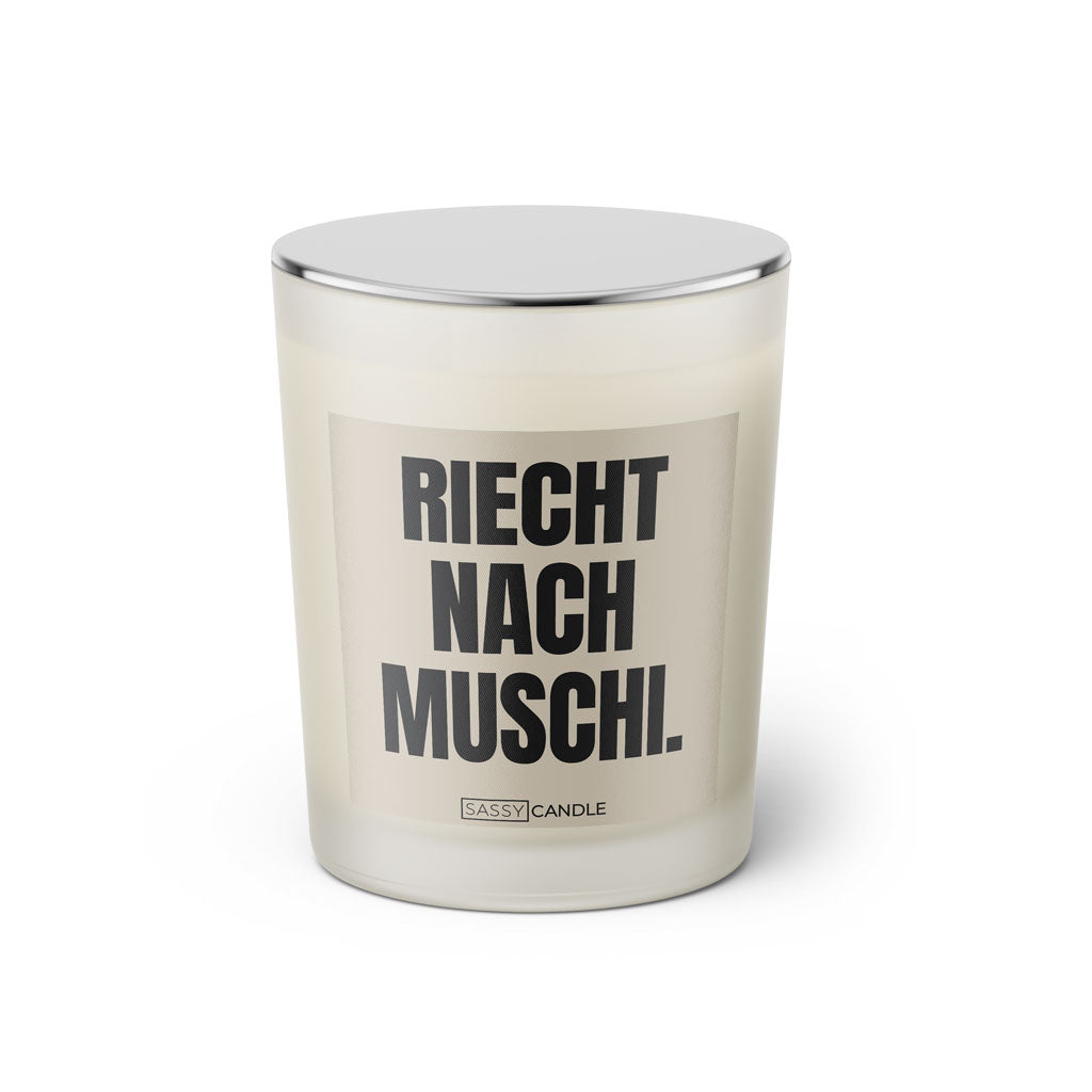 Duftkerze mit Spruch: Riecht nach Muschi. Farbe beige und schwarz von Sassy Candle.