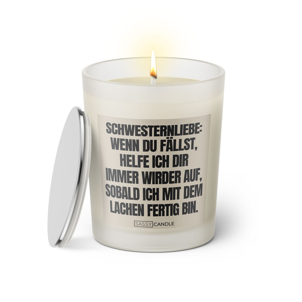 Duftkerze mit witzigem Spruch: Schwesternliebe: Wenn du fällst, helfe ich dir immer wieder auf, sobald ich mit dem lachen fertig bin. Farbe beige und schwarze Schrift. Kerzenglas mit silbernem Deckel von SassyCandle.