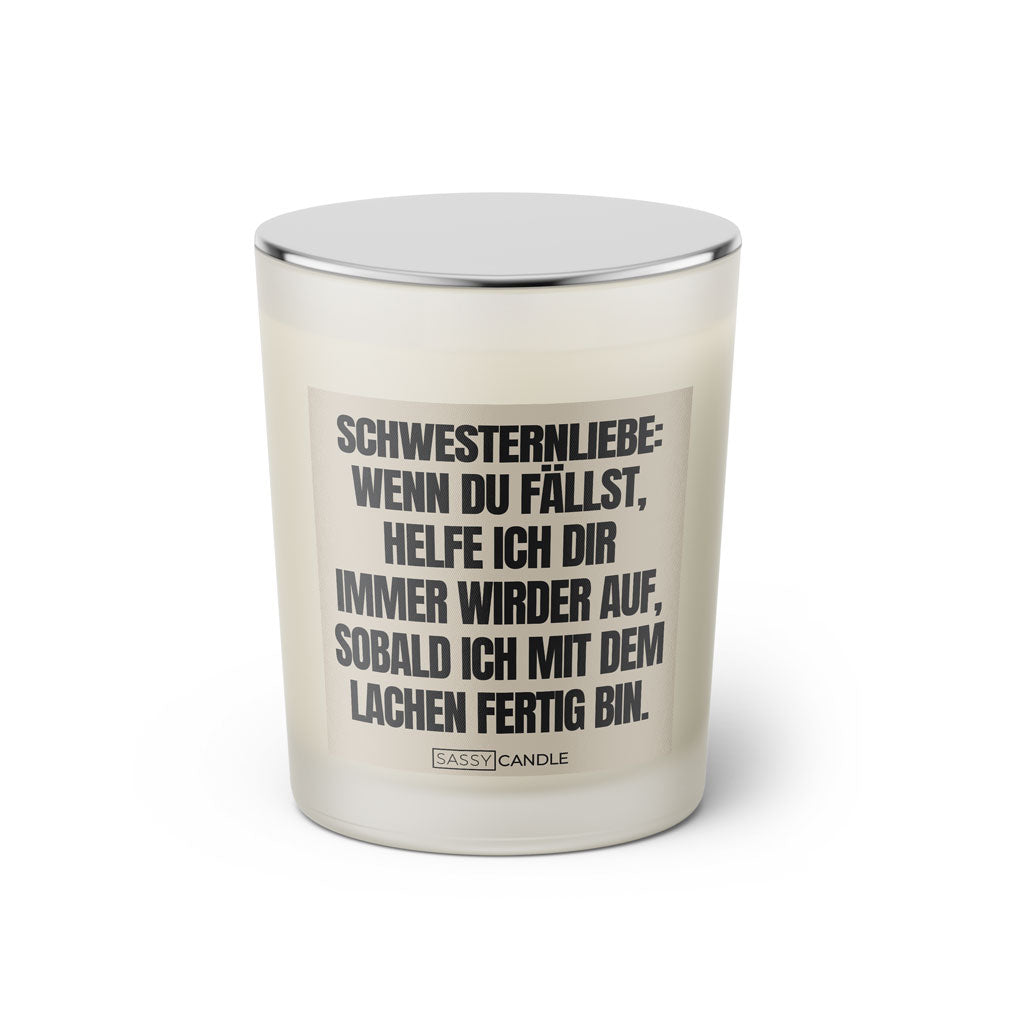 Duftkerze mit witzigem Spruch: Schwesternliebe: Wenn du fällst, helfe ich dir immer wieder auf, sobald ich mit dem lachen fertig bin. Farbe beige und schwarze Schrift. Kerzenglas mit silbernem geschlossenem Deckel von SassyCandle.