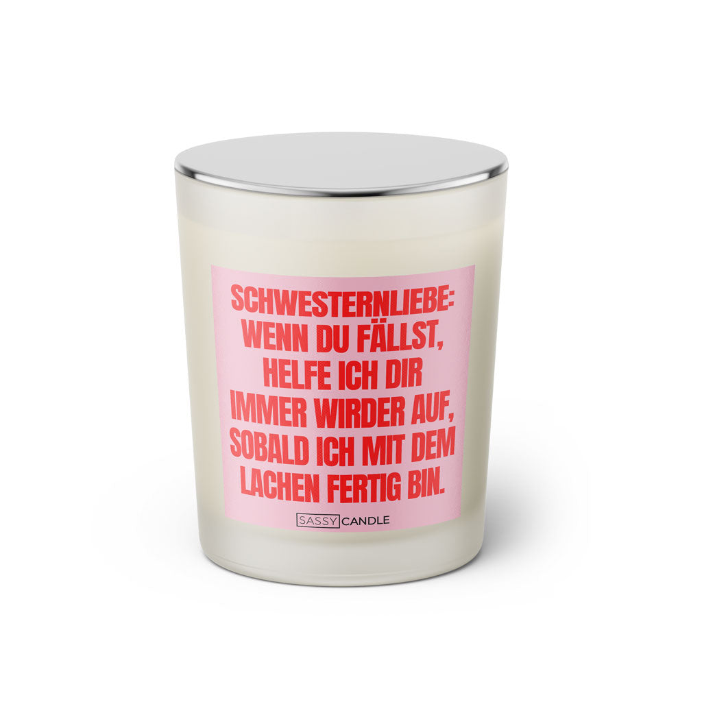 Duftkerze mit witzigem Spruch: Schwesternliebe: Wenn du fällst, helfe ich dir immer wieder auf, sobald ich mit dem lachen fertig bin. Farbe rosa und pinke Schrift. Kerzenglas mit silbernem geschlossenem Deckel von SassyCandle.