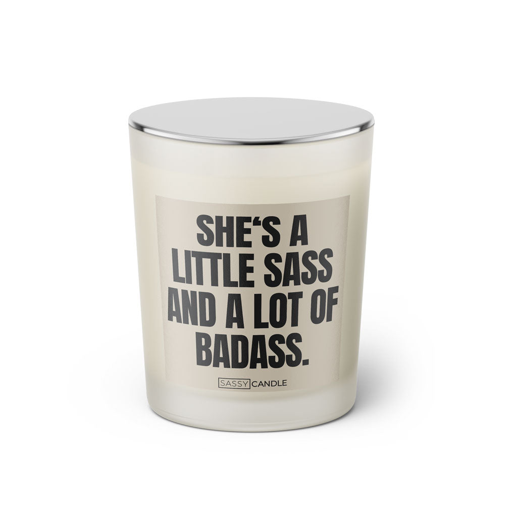 Duftkerze mit witzigen Spruch: She's a little sass and a lot of badass. Farbe beige und schwarz mit silbernen Deckel von Sassy Candle.
