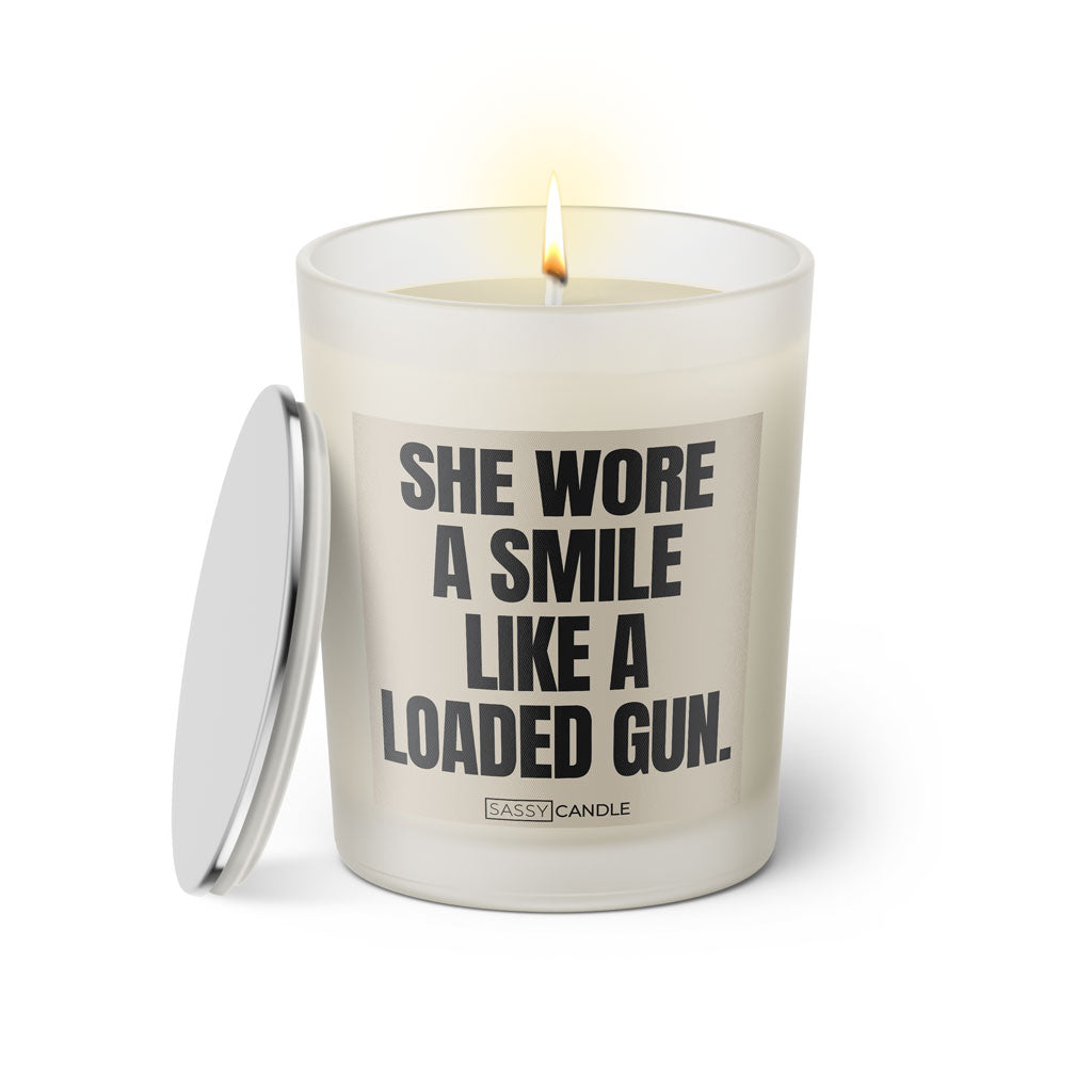 Duftkerze mit witzigen Spruch: She wore a smile like a loaded gun. Farbe beige und schwarz von Sassy Candle.