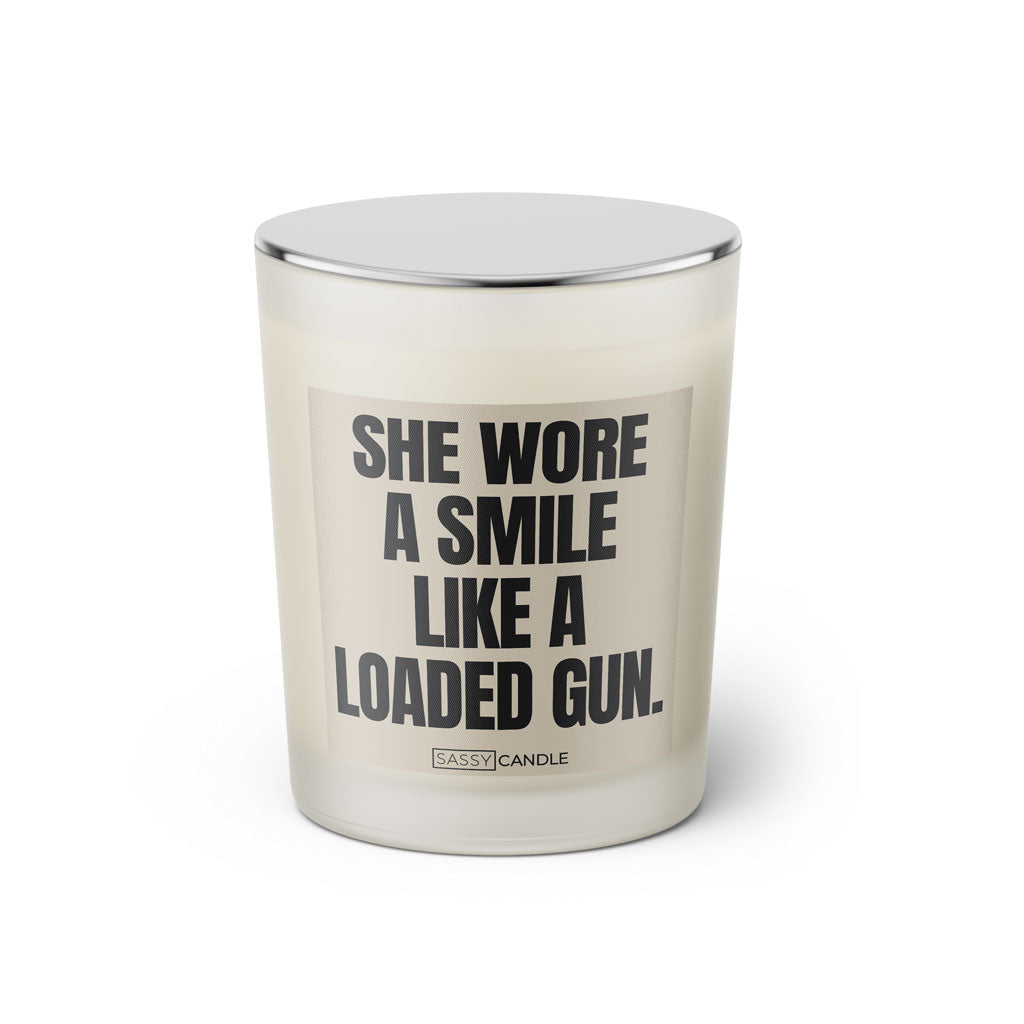 Duftkerze mit witzigen Spruch: She wore a smile like a loaded gun. Farbe beige und schwarz von Sassy Candle.