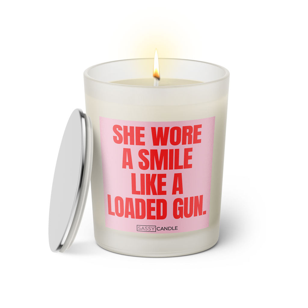 Duftkerze mit witzigen Spruch: She wore a smile like a loaded gun. Farbe rosa und pink von Sassy Candle.